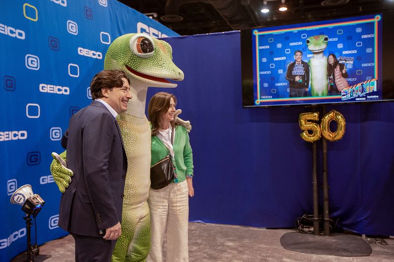 © Reuters. FILE PHOTO: People pose with 'gecko' from GEICO in Omaha, Nebraska, U.S. May 5, 2023. REUTERS/Rachel Mummey/File Photo