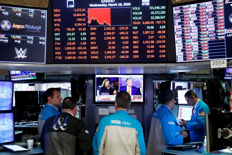 © Reuters. FILE PHOTO: Traders watch a screen on the floor of the New York Stock Exchange in New York, U.S., March 18, 2020. REUTERS/Lucas Jackson/File Photo