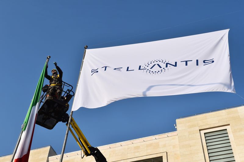 © Reuters. FILE PHOTO: Workers install a flag with the logo of Stellantis at the main entrance of FCA Mirafiori plant in Turin, Italy, January 18, 2021. REUTERS/Massimo Pinca/File Photo