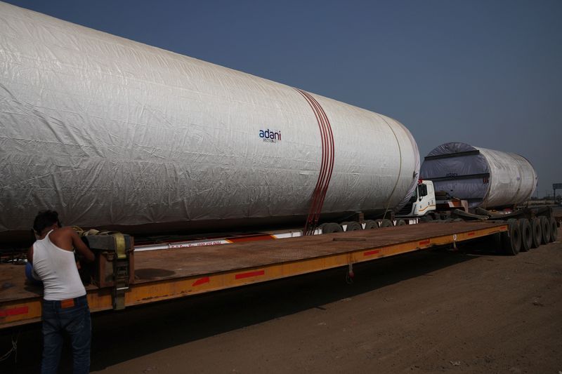 © Reuters. FILE PHOTO: Windmill tubes of Adani Green Energy are loaded on transport trucks along Ahmedabad-Mundra National Highway near Viramgam in the western state of Gujarat, India, November 25, 2024. REUTERS/Amit Dave/File Photo