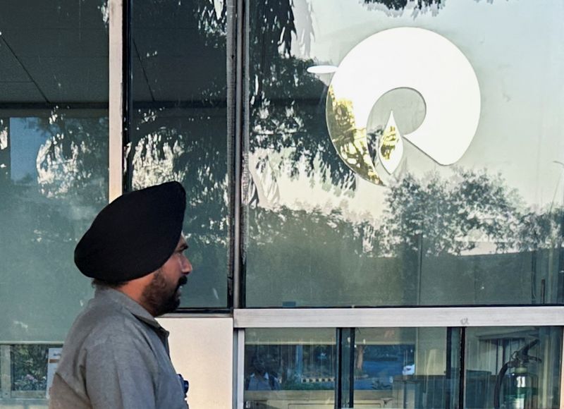 © Reuters. FILE PHOTO: A guard walks past the Reliance Industries logo near the entrance of Dhirubhai Ambani Knowledge City in Navi Mumbai, March 15, 2024. REUTERS/Francis Mascarenhas/File Photo