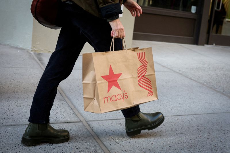 © Reuters. FILE PHOTO: A shopper walks on 5th Avenue shopping district during the holiday season in New York City, U.S., November 25, 2024. REUTERS/Brendan McDermid/File Photo