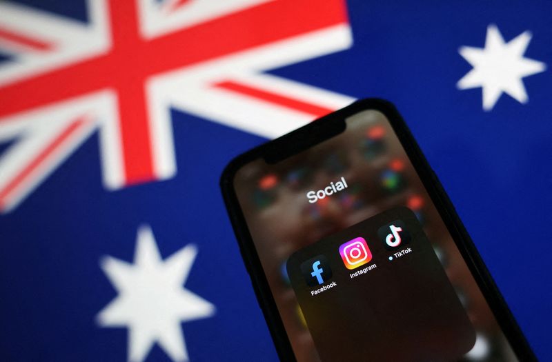 © Reuters. Facebook, Instagram and TikTok apps are seen on a smartphone in front of an Australian flag, in this illustration taken November 29, 2024. REUTERS/Edgar Su/Illustration