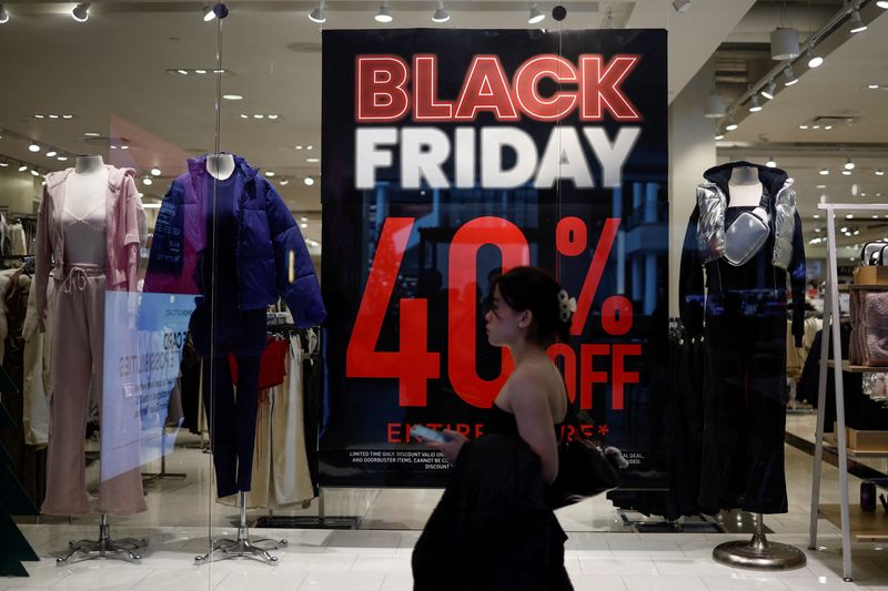 © Reuters. FILE PHOTO: A shopper walks past an advertisement for Black Friday sales displayed in a store window at Pentagon City in Arlington, Virginia, U.S., November 27, 2024. REUTERS/Benoit Tessier/File Photo