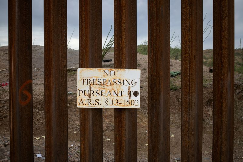 © Reuters. FILE PHOTO: A sign attached to the Border Wall reads,