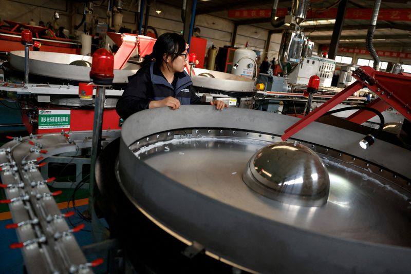 © Reuters. FILE PHOTO: A worker monitors the production line of drip tape fittings at a factory of DAYU Water Group Co, in Jiuquan, during an organised media tour in Gansu province, China October 18, 2024. REUTERS/Tingshu Wang/File Photo