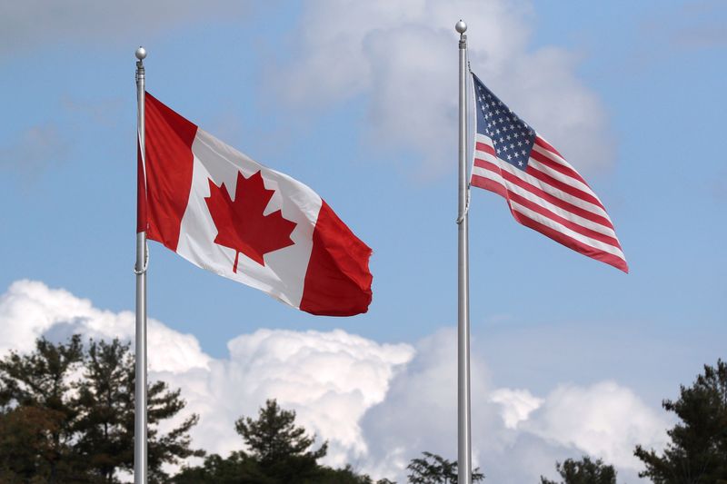 © Reuters. FILE PHOTO: A U.S. and a Canadian flag flutter at the Canada-United States border crossing at the Thousand Islands Bridge in Lansdowne, Ontario, Canada September 28, 2020.  REUTERS/Lars Hagberg/File Photo