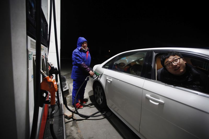 © Reuters. FILE PHOTO: An employee fills the tank of a car with petrol at a gas station in Shanghai February 7, 2012.  REUTERS/Aly Song/File Photo