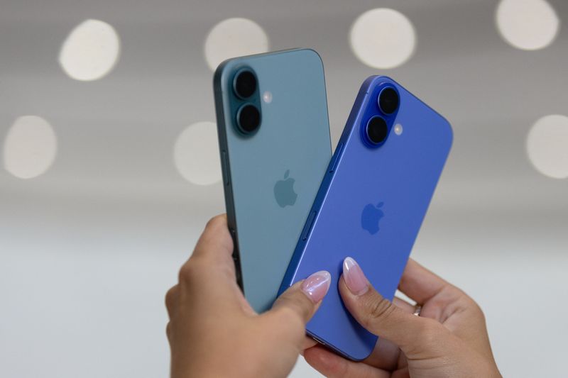 © Reuters. FILE PHOTO: An attendee holds two iPhones 16 as Apple holds an event at the Steve Jobs Theater on its campus in Cupertino, California, U.S. September 9, 2024. REUTERS/Manuel Orbegozo/File Photo