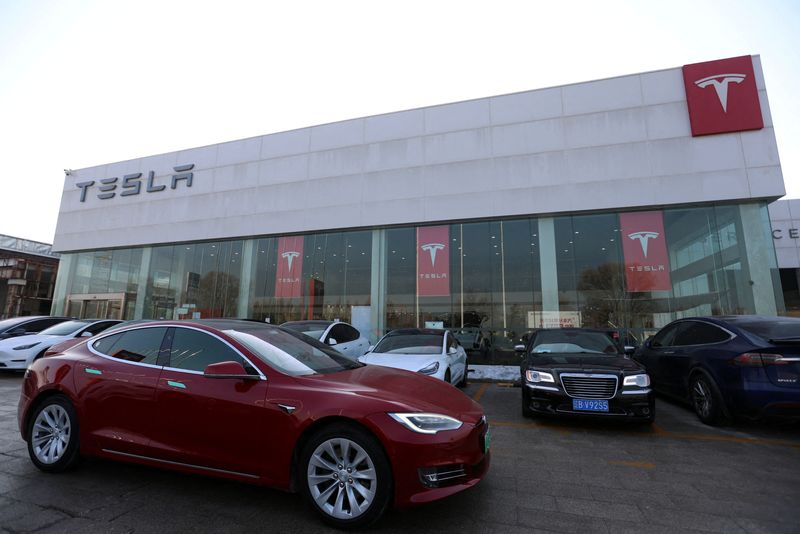 © Reuters. FILE PHOTO: A Tesla car is driven past a store of the electric vehicle (EV) maker in Beijing, China January 4, 2024. REUTERS/Florence Lo/File Photo