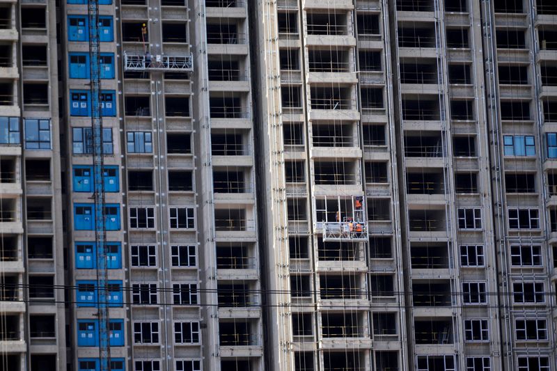 © Reuters. FILE PHOTO: Workers install windows for residential buildings under construction in Shanghai, China, October 10, 2022. REUTERS/Aly Song/File Photo