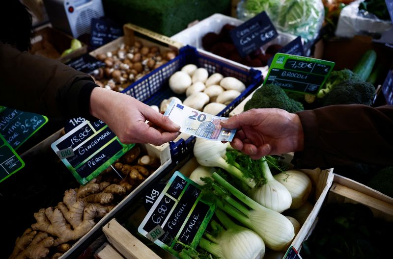 © Reuters. FILE PHOTO: A shopper pays with a twenty Euro banknote at a local market in Nantes, France, February 1, 2024. REUTERS/Stephane Mahe/File Photo