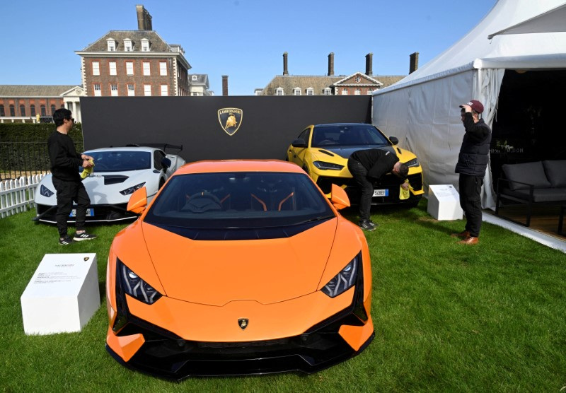 © Reuters. FILE PHOTO: Workers clean Lamborghini cars on display at the Salon Prive, a three day automobile event which showcases both new and classic luxury and sports vehicles, at the Royal Chelsea Hospital in London, Britain, April 20, 2023. REUTERS/Toby Melville/File Photo