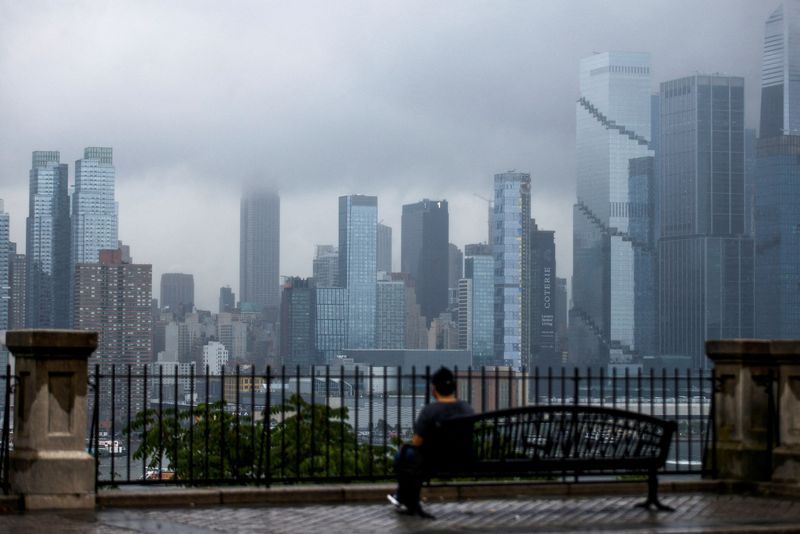 © Reuters. A person looks at the Empire State building and the New York skyline covered in fog during a rainy morning, as seen from Weehawken, New Jersey, U.S., July 23, 2024.  REUTERS/Eduardo Munoz/File Photo