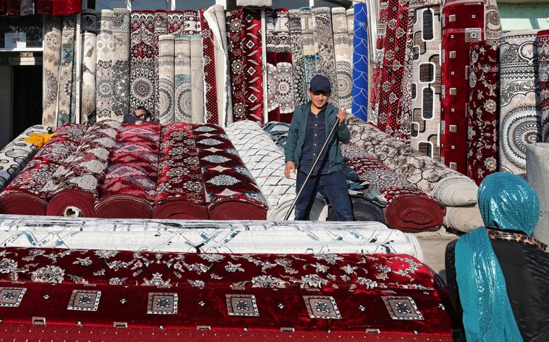 © Reuters. A vendor sells carpets at a local market in the settlement of Hulbuk, formerly known as Vose, in the Khatlon region, Tajikistan, December 12, 2024. REUTERS/Stringer