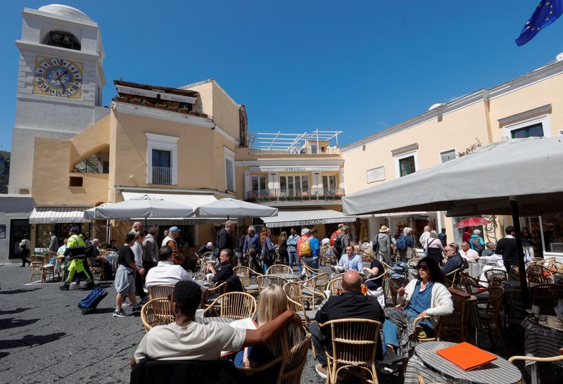 © Reuters. FILE PHOTO: People sit at the tables outside restaurants and cafes on Capri Island, Italy, April 18, 2024. REUTERS/Ciro De Luca/File Photo