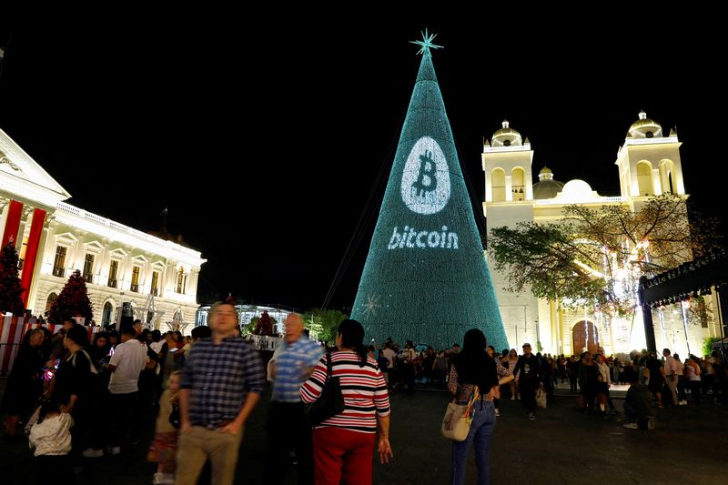 © Reuters. FILE PHOTO: People gather around a Christmas tree light installation displaying a Bitcoin logo in San Salvador, El Salvador, December 9,2024. REUTERS/Jose Cabezas/File Photo