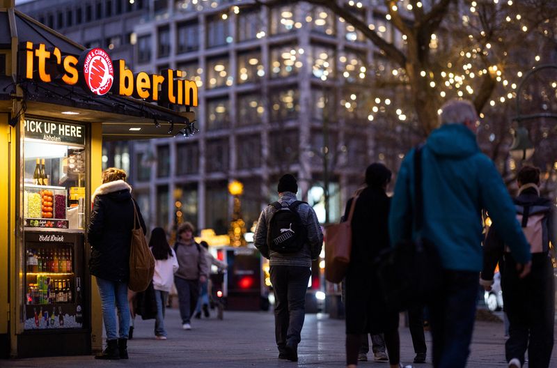 © Reuters. FILE PHOTO: People walk next to a Doner kebab and Currywurst booth at Kurfuerstendamm shopping street during Christmas season in Berlin, Germany, December 18, 2023.  REUTERS/Lisi Niesner/File Photo