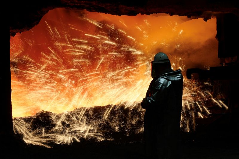 © Reuters. FILE PHOTO: A steel worker in heat protection gear is silhouetted against the sparkling fire of Europe's largest furnace with a daily raw iron production of 12,000 tons, at the steel plant of ThyssenKrupp in Duisburg, Germany, November 16, 2023.  REUTERS/Wolfgang Rattay/File Photo