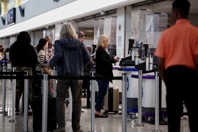 © Reuters. FILE PHOTO: Travelers wait in line at Ronald Reagan National Airport (DCA) ahead of the Thanksgiving holiday in Arlington, Virginia, U.S., November 27, 2024. REUTERS/Benoit Tessier/File Photo