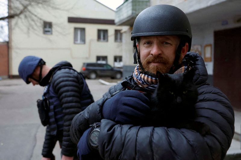 © Reuters. FILE PHOTO: Reuters safety advisor Ryan Evans holds a cat during a news assignment, as Russia's attack on Ukraine continues, during intense shelling in Kramatorsk, Ukraine, December 26, 2022. REUTERS/Clodagh Kilcoyne/File Photo