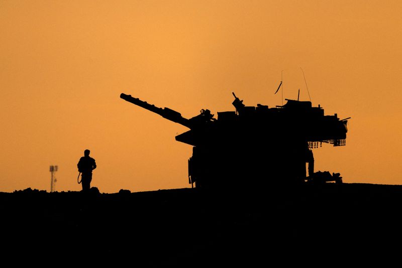 © Reuters. FILE PHOTO: The silhouettes of a military vehicle and a soldier are seen near the Gaza border, amid the ongoing conflict in Gaza between Israel and Hamas, in Israel, December 16, 2024. REUTERS/Amir Cohen/File Photo