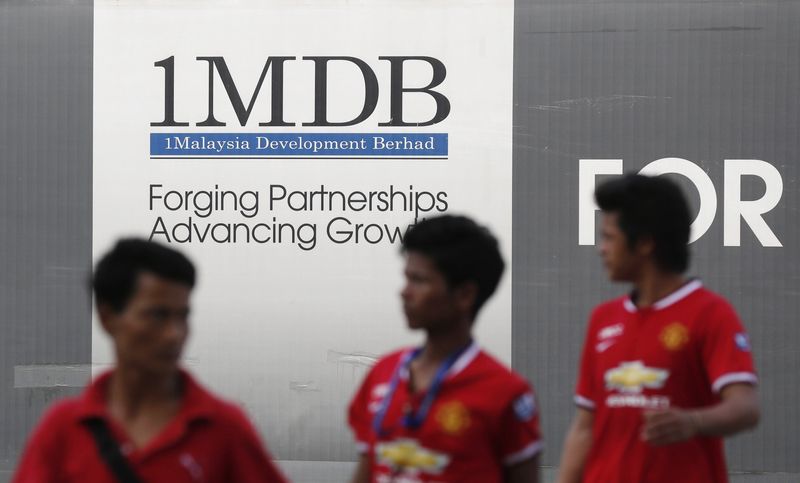 © Reuters. Men walk past a 1 Malaysia Development Berhad (1MDB) billboard at the funds flagship Tun Razak Exchange development in Kuala Lumpur March 1, 2015. REUTERS/Olivia Harris/Files