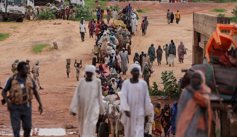 © Reuters. FILE PHOTO: Sudanese people, who fled the conflict in Murnei in Sudan's Darfur region, cross the border between Sudan and Chad in Adre, Chad August 4, 2023. REUTERS/Zohra Bensemra/File Photo