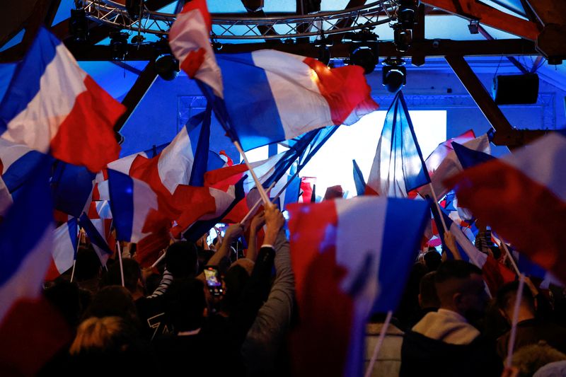 © Reuters. Supporters of the French far-right National Rally (Rassemblement National - RN) party wave French flags, during a political rally in Etrepagny, France, December 15, 2024. REUTERS/Stephanie Lecocq/File Photo