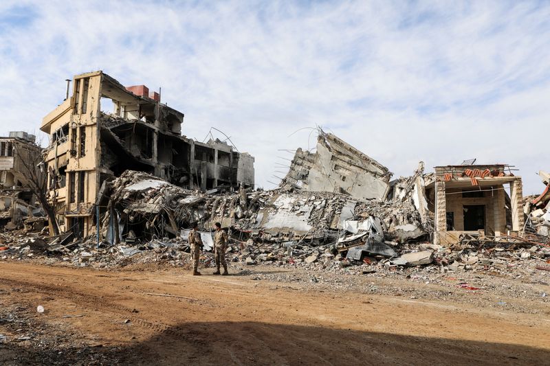 © Reuters. FILE PHOTO: Lebanese army members stand near rubble at a damaged site after the ceasefire between Israel and Hezbollah, in the Lebanese village of Khiam, December 23, 2024. REUTERS/Karamallah Daher/File Photo