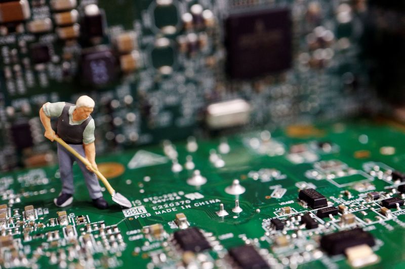 © Reuters. FILE PHOTO: A worker miniature is placed among printed circuit boards with semiconductor chips, in this illustration picture taken July 5, 2023. REUTERS/Florence Lo/Illustration/File Photo