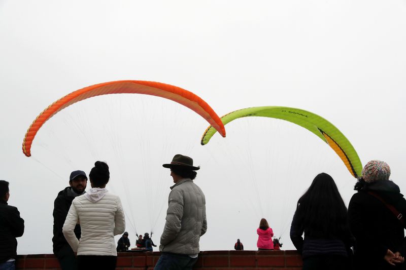 © Reuters. FILE PHOTO: People hang out at a paraglider park on a cliff overlooking the Pacific ocean in the district of Miraflores in Lima, Peru, August 1, 2019. REUTERS/Susana Vera/File Photo