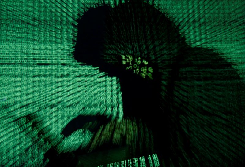 © Reuters. FILE PHOTO: A man holds a laptop computer as cyber code is projected on him in this illustration picture taken on May 13, 2017. REUTERS/Kacper Pempel/Illustration/File Photo