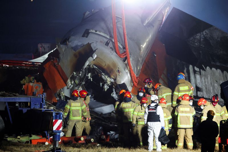 © Reuters. Rescuers work the wreckage of an aircraft that went off the runway and crashed, at Muan International Airport, in Muan, South Korea, December 29, 2024. REUTERS/Kim Hong-Ji