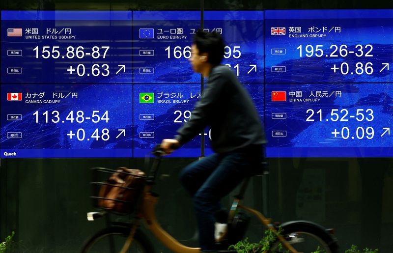 © Reuters. FILE PHOTO: A man rides a bicycle past an electronic screen displaying the current Japanese Yen exchange rate against the U.S. dollar and other foreign currencies in Tokyo, Japan May 2, 2024, REUTERS/Issei Kato/File Photo