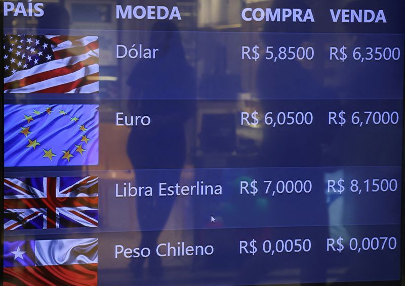 © Reuters. FILE PHOTO: A woman is reflected on a screen that shows the real-U.S. dollar exchange rate and that of several foreign currencies in Rio de Janeiro, Brazil, December 26, 2024. REUTERS/Ricardo Moraes/File Photo