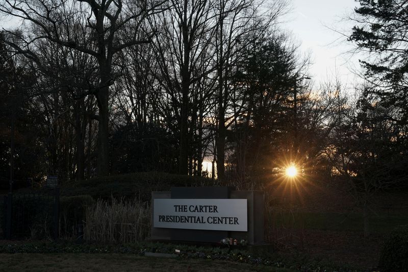 © Reuters. The sun sets behind The Carter Presidential Center's sign, after the death of former U.S. President Jimmy Carter at the age of 100, in Atlanta, Georgia, U.S., December 29, 2024. REUTERS/Elijah Nouvelage