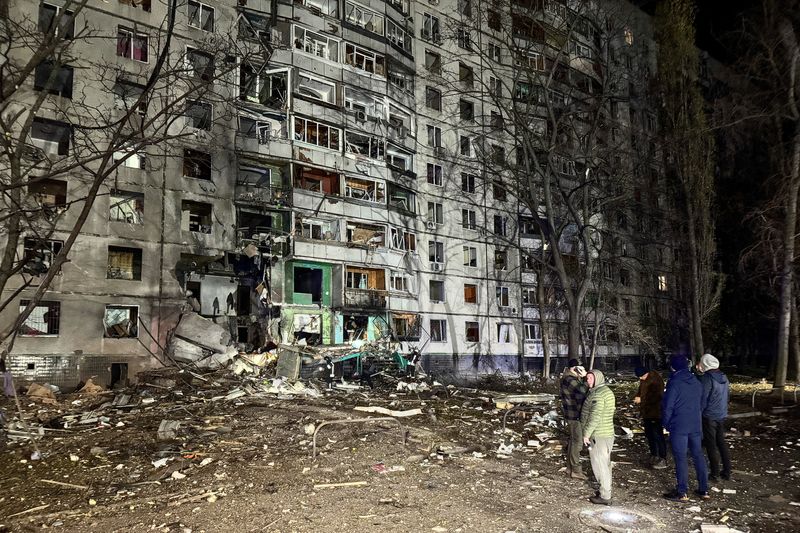 © Reuters. FILE PHOTO: Residents stand next to their apartment building hit by a Russian air strike, amid Russia's attack on Ukraine, in Kharkiv, Ukraine November 8, 2024. REUTERS/Vitalii Hnidyi/File Photo