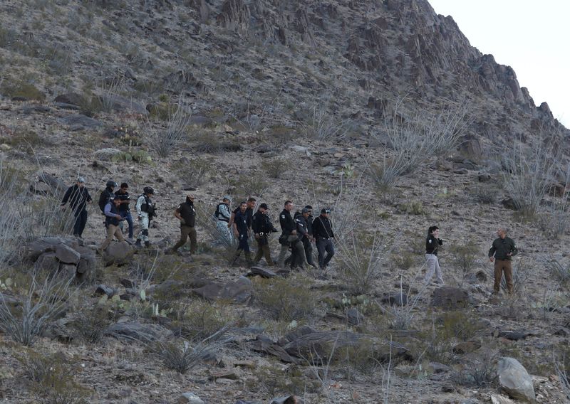 © Reuters. Authorities escort two suspects after the death of a National Migration Institute agent, in Samalayuca, on the outskirts of Ciudad Juarez, Mexico, December 30, 2024. REUTERS/Carlos Sanchez     TPX IMAGES OF THE DAY