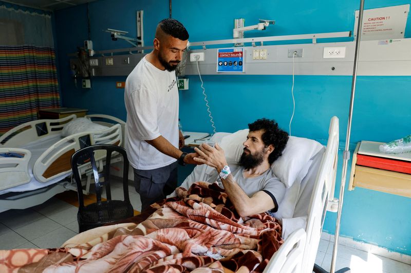 © Reuters. FILE PHOTO: Palestinian Moazaz Obaiyat, who was released from Israeli jail, takes a cup of water, in a hospital in Bethlehem in the Israeli-occupied West Bank July 11, 2024. REUTERS/Mussa Qawasma/File Photo