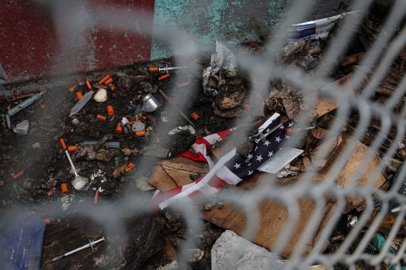 © Reuters. FILE PHOTO: Debris left by drug users lies next to a tattered  U.S. flag, in the Bronx borough of New York City, U.S., June 15, 2023.  REUTERS/Shannon Stapleton/File Photo