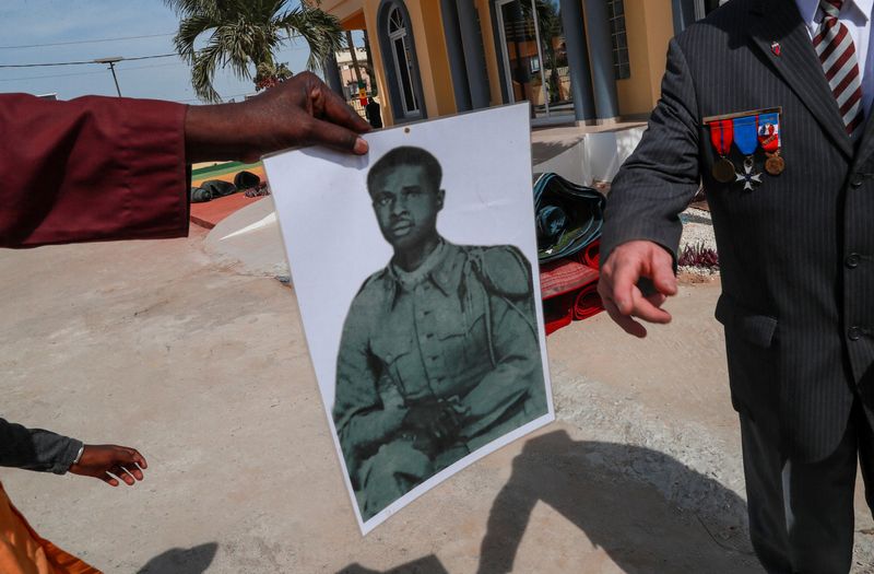 © Reuters. A family member shows a photograph of his relative that was killed during the Thiaroye massacre as Senegal commemorates the 80th anniversary of a massacre of African soldiers who fought for France during WW2, and were gunned down by French troops in 1944 for demanding fair treatment and pay in Thiaroye, Senegal December 1, 2024. REUTERS/Amira Karaoud