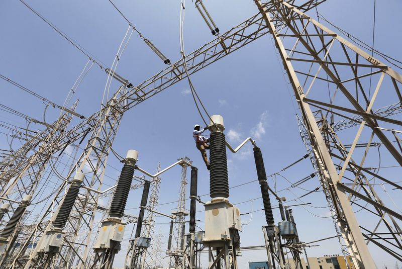 © Reuters. FILE PHOTO: A technician repairs power supply lines at a power plant of Adani Power at Mundra Port in the western Indian state of Gujarat April 2, 2014. REUTERS/Amit Dave/File Photo