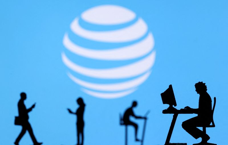 © Reuters. FILE PHOTO: Small toy figures with laptops and smartphones are seen in front of displayed AT&T logo, in this illustration taken December 5, 2021. REUTERS/Dado Ruvic/Illustration/File Photo