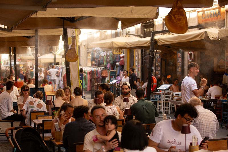 © Reuters. FILE PHOTO: People sit in a restaurant in Palermo, Sicily, Italy July 17, 2024. REUTERS/Antonio Cascio/File Photo