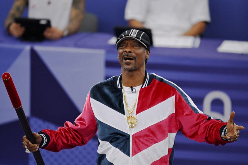 © Reuters. FILE PHOTO: Paris 2024 Olympics - Breaking - B-Girls Pre-Qualifier Battle - La Concorde 1, Paris, France - August 09, 2024. Snoop Dogg holds a baton to signal the official start of the competition. REUTERS/Angelika Warmuth/File Photo