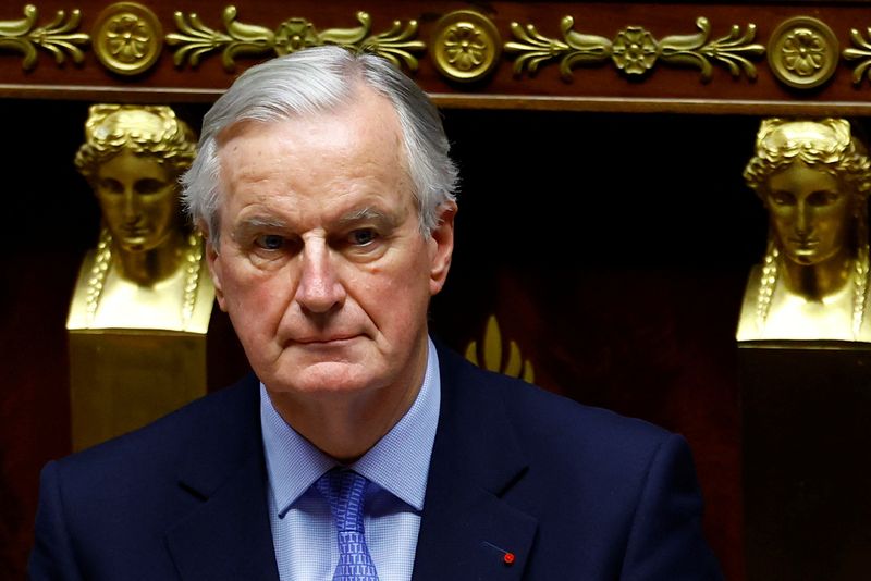 © Reuters. French Prime Minister Michel Barnier arrives to deliver a speech during a debate on two motions of no-confidence against the French government, tabled by the alliance of left-wing parties the