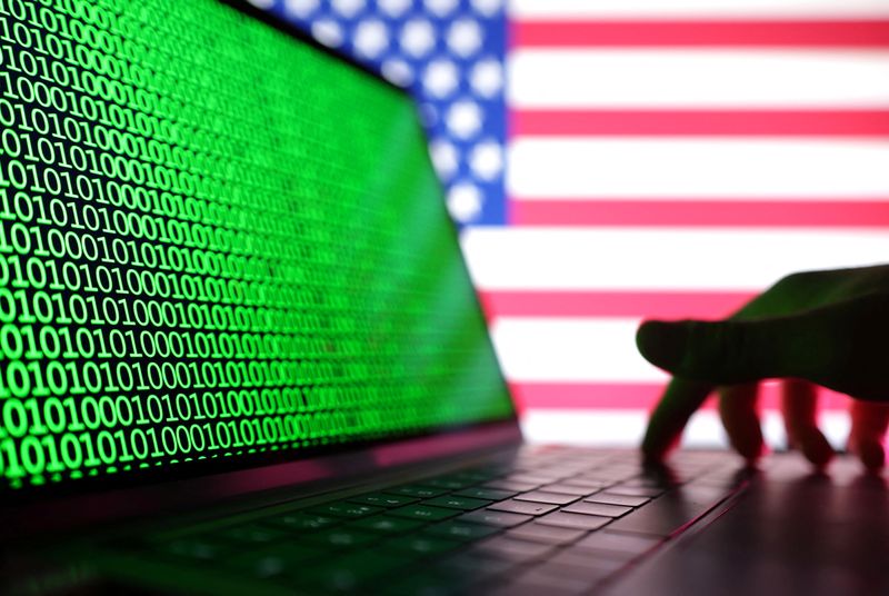 © Reuters. A hand is seen on a laptop with binary codes displayed in front of the USA flag in this illustration taken, August 19, 2022. REUTERS/Dado Ruvic/Illustration