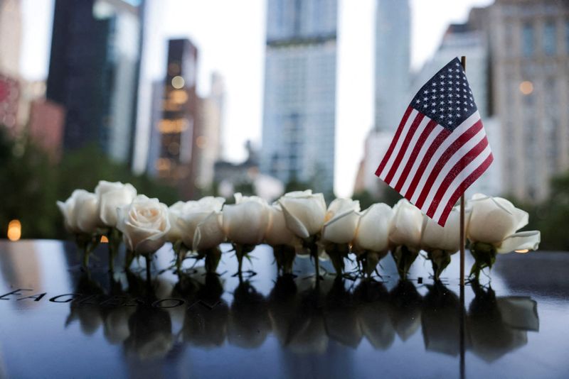 © Reuters. FILE PHOTO: A U.S. national flag and flowers are placed at the 9/11 Memorial and Museum pool on the day of the 23rd anniversary of the September 11, 2001 attacks on the World Trade Center, in the Manhattan borough of New York City, U.S., September 11, 2024. REUTERS/Kent J.Edwards/File Photo