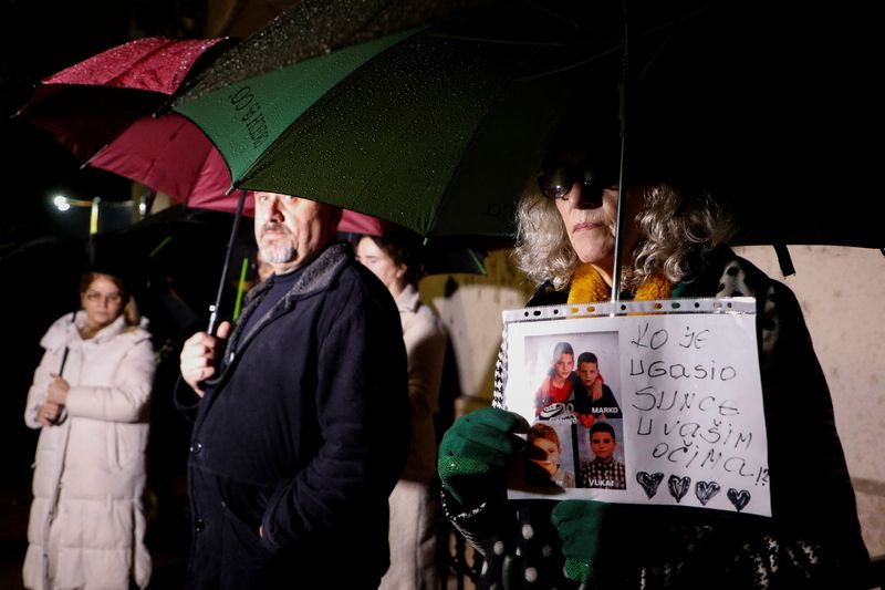 © Reuters. A woman holds a placard with pictures of victims during protest as government hold National Security Council after a gunman in Cetinje killed several people in a rampage, in Podgorica Montenegro, January 3, 2025. REUTERS/Stevo Vasiljevic